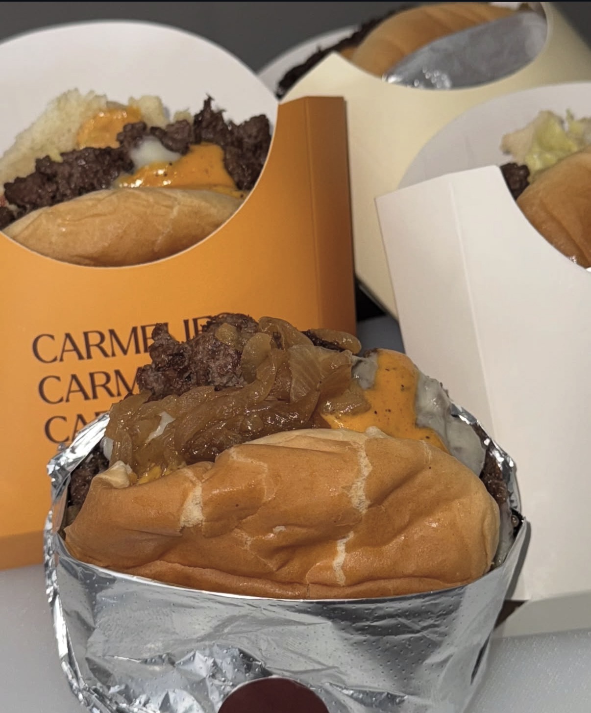 Smashburgers in orange and cream Carmelies boxes stamped with the logo